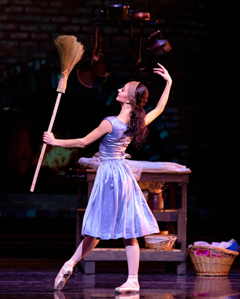 Buse as Cinderella with broom on stage