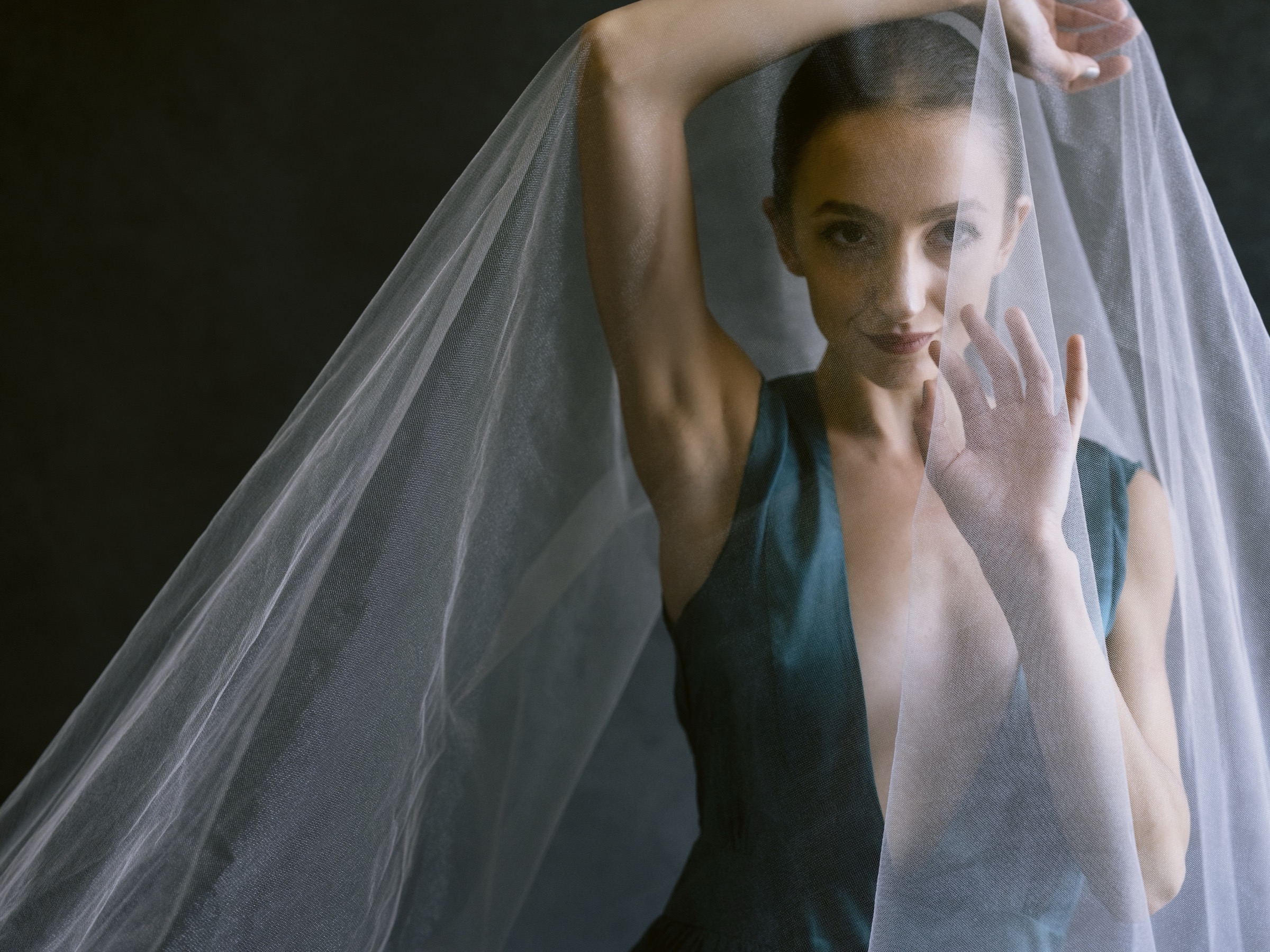 Buse Babadag reaching through sheer veil — editorial portrait